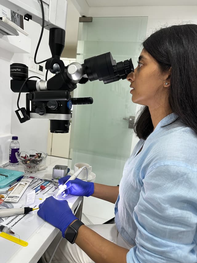 Dr. Roopa working at the dental microscope